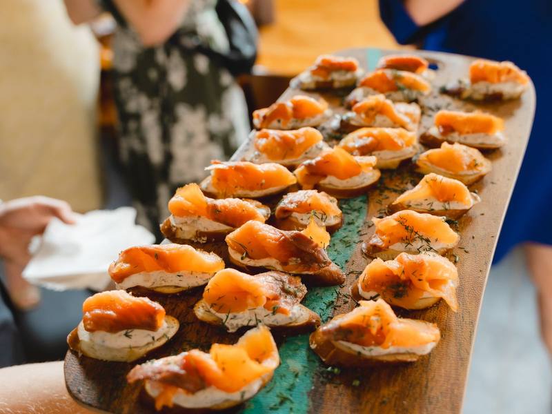 Smoked salmon canapés passed on a wooden board