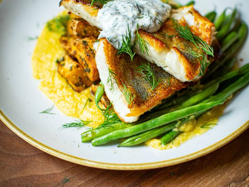 Plated fish with green beans and herb sauce