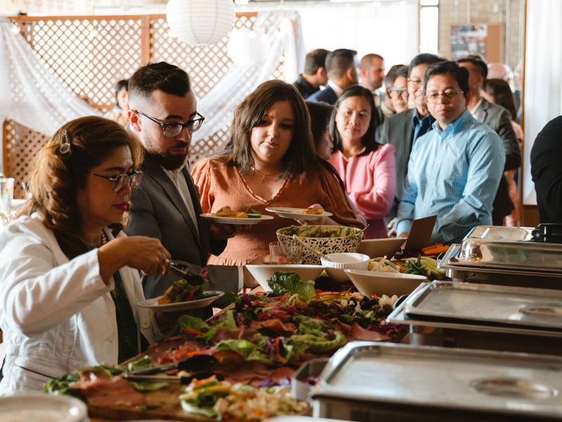 Guests helping themselves at a buffet of shared dishes